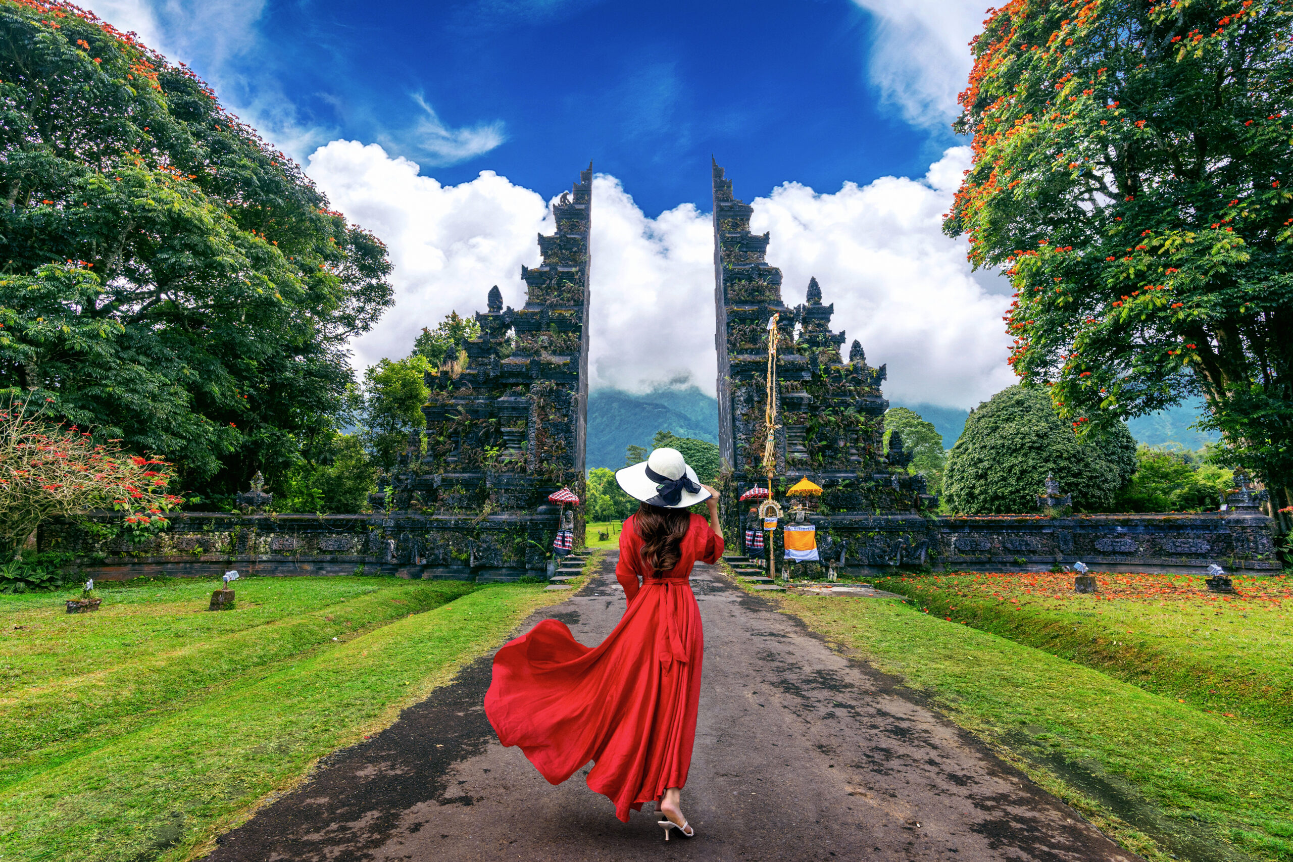 woman walking big entrance gate bali indonesia scaled